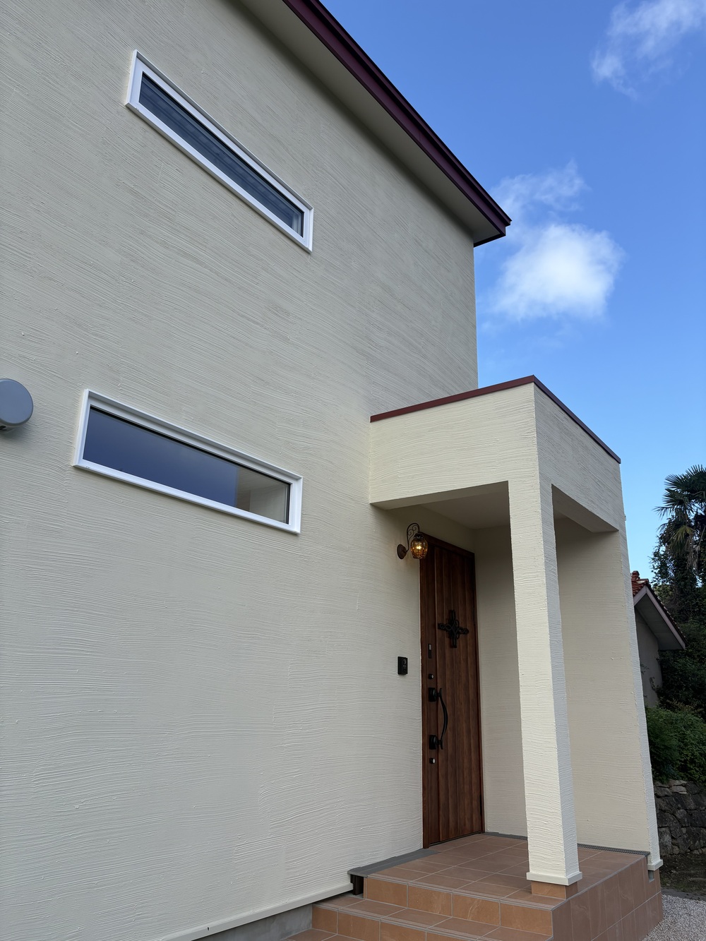 えんじ色のガルバ屋根と白壁のやさしいお家