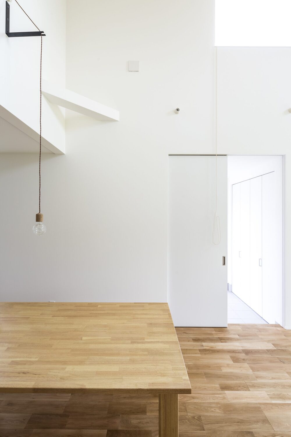 光が降りる吹き抜けとオープンな階段の家