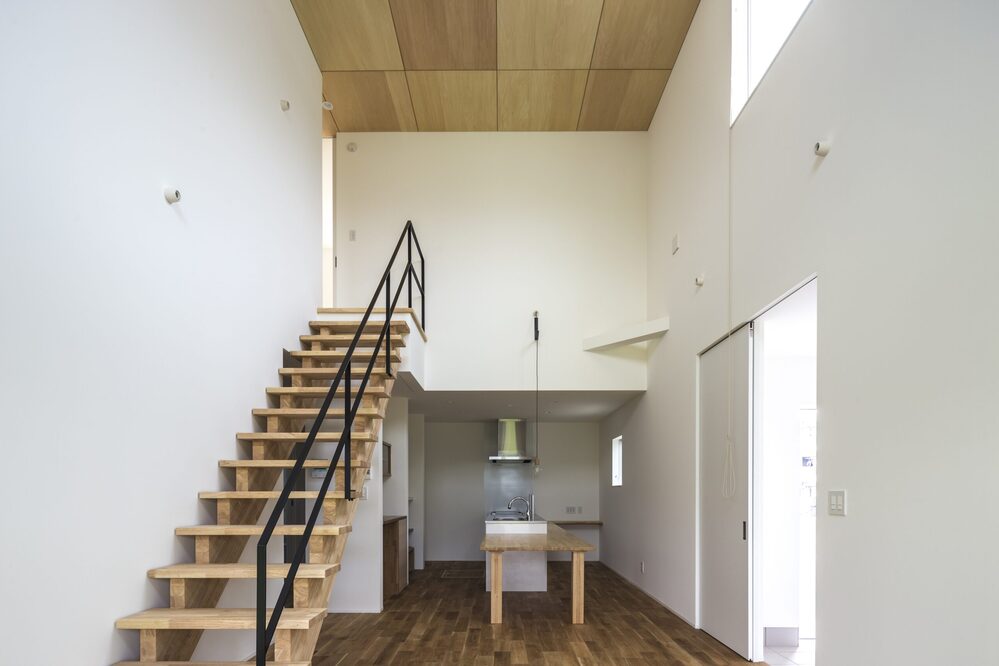 光が降りる吹き抜けとオープンな階段の家