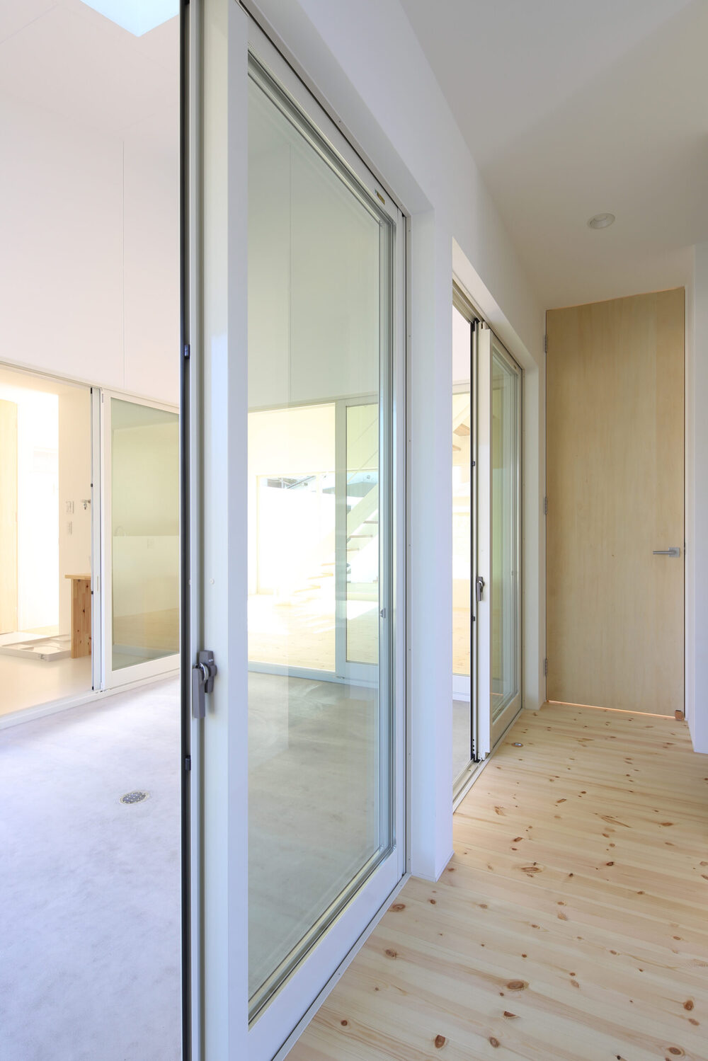 中庭から光が満ちる、白い箱の家