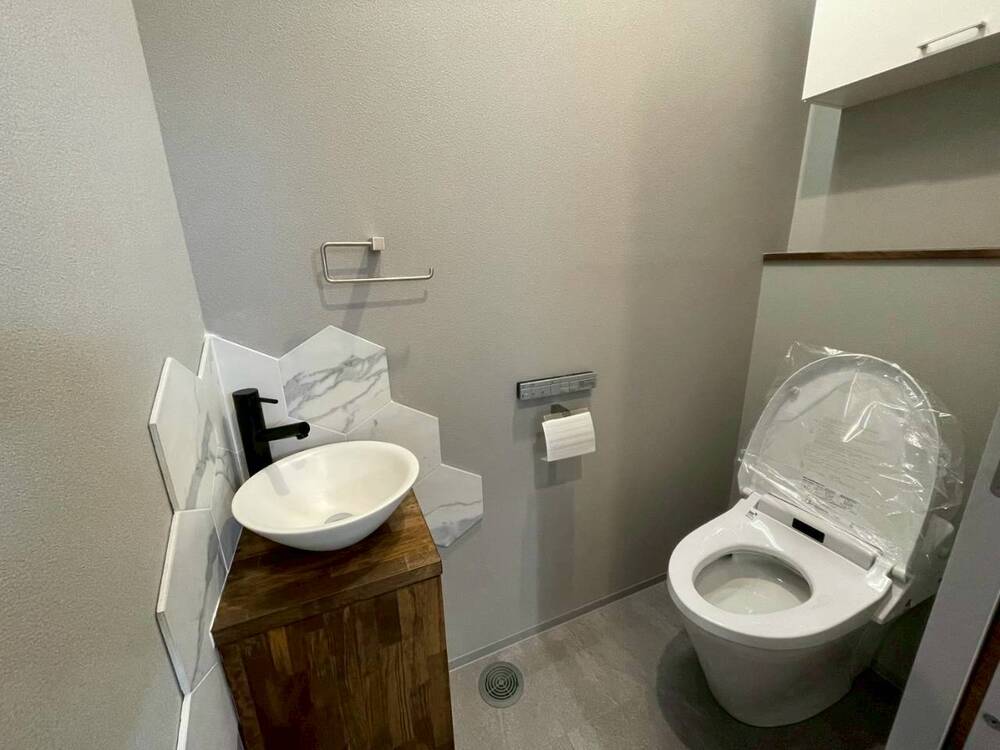 素材感が映える、ホテルライクな洗面付きトイレスペース