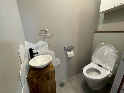 素材感が映える、ホテルライクな洗面付きトイレスペース